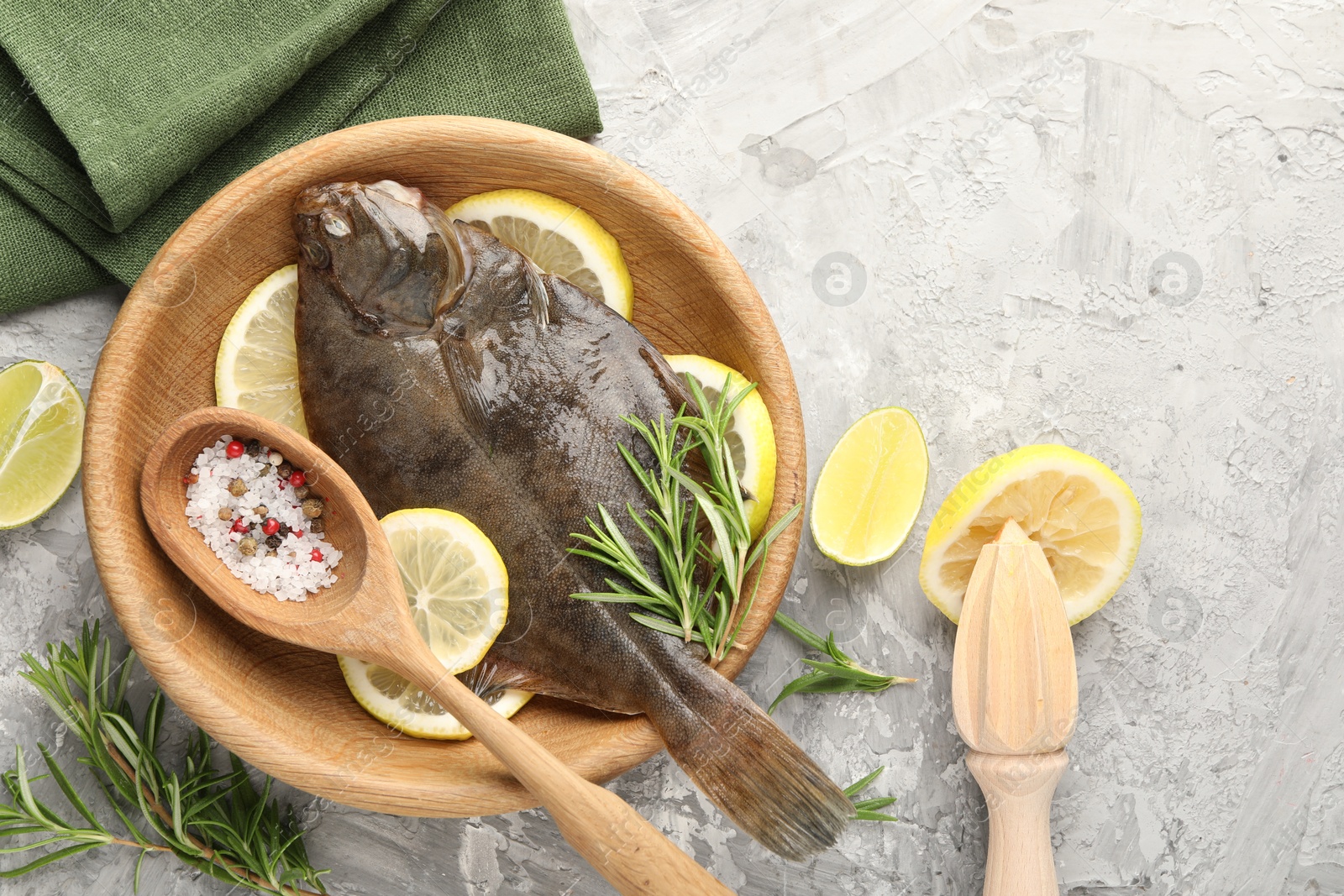 Fresh raw flounder fish, spices and wooden juicer on grey table, flat lay. Seafood Photo of Fresh raw flounder fish, spices and wooden juicer on grey table, flat lay. Seafood