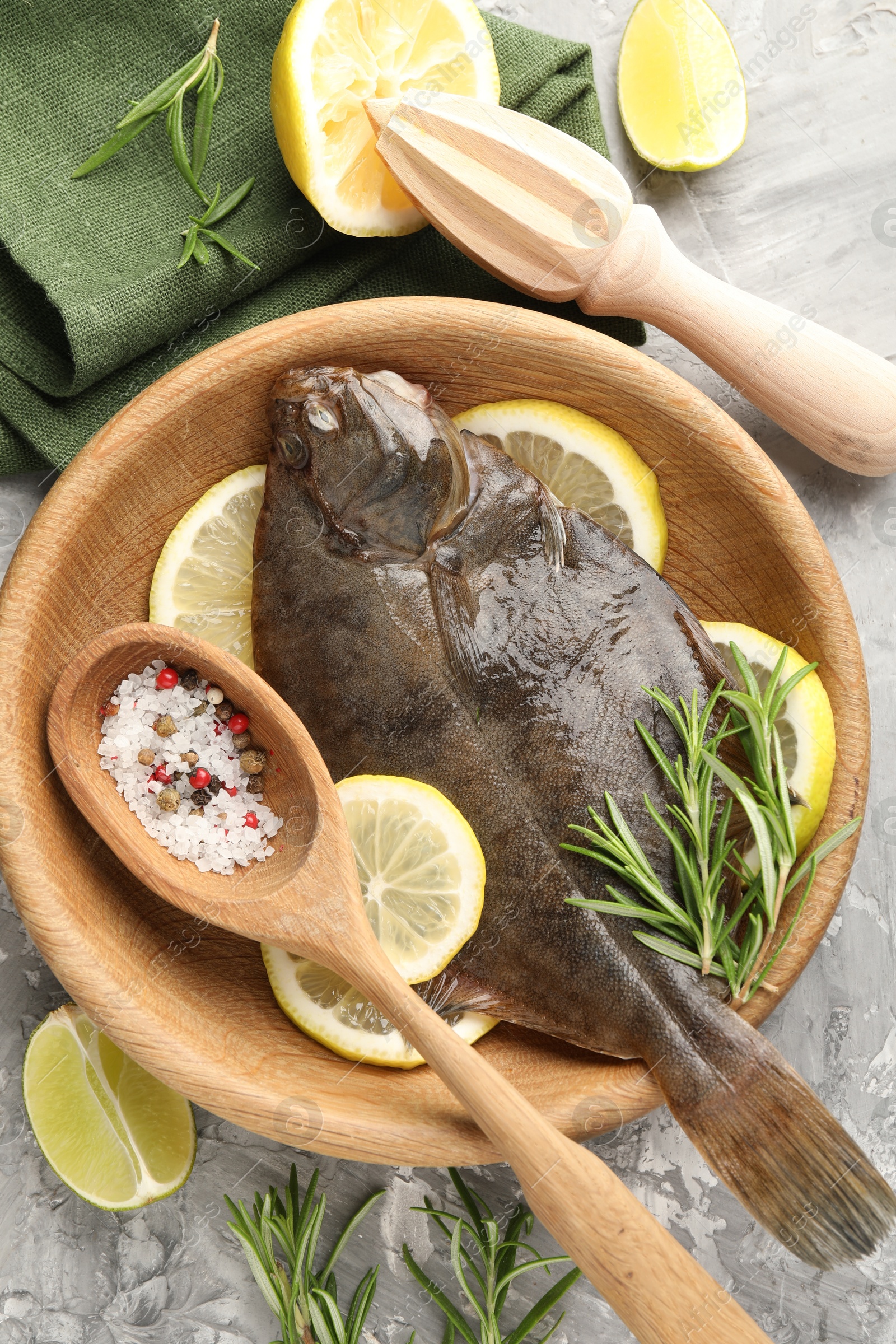 Fresh raw flounder fish, spices and wooden juicer on grey table, flat lay. Seafood Photo of Fresh raw flounder fish, spices and wooden juicer on grey table, flat lay. Seafood