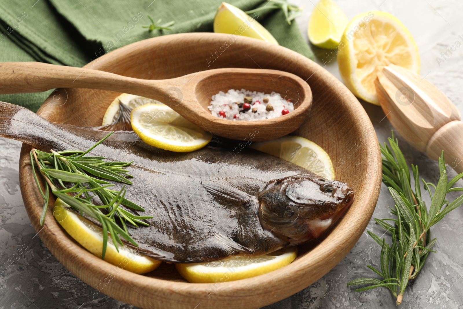 Fresh raw flounder fish, spices and wooden juicer on grey table, closeup. Seafood Photo of Fresh raw flounder fish, spices and wooden juicer on grey table, closeup. Seafood