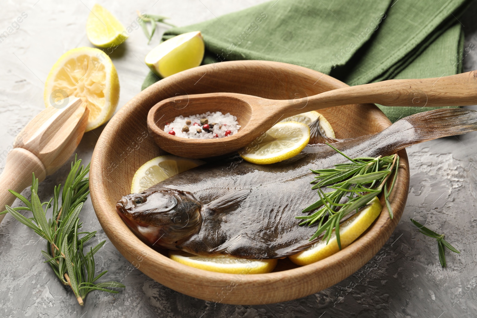 Fresh raw flounder fish, spices and wooden juicer on grey table, closeup. Seafood Photo of Fresh raw flounder fish, spices and wooden juicer on grey table, closeup. Seafood