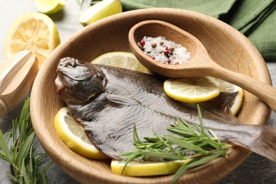 Photo of Fresh raw flounder fish, spices and wooden juicer on table, closeup. Seafood