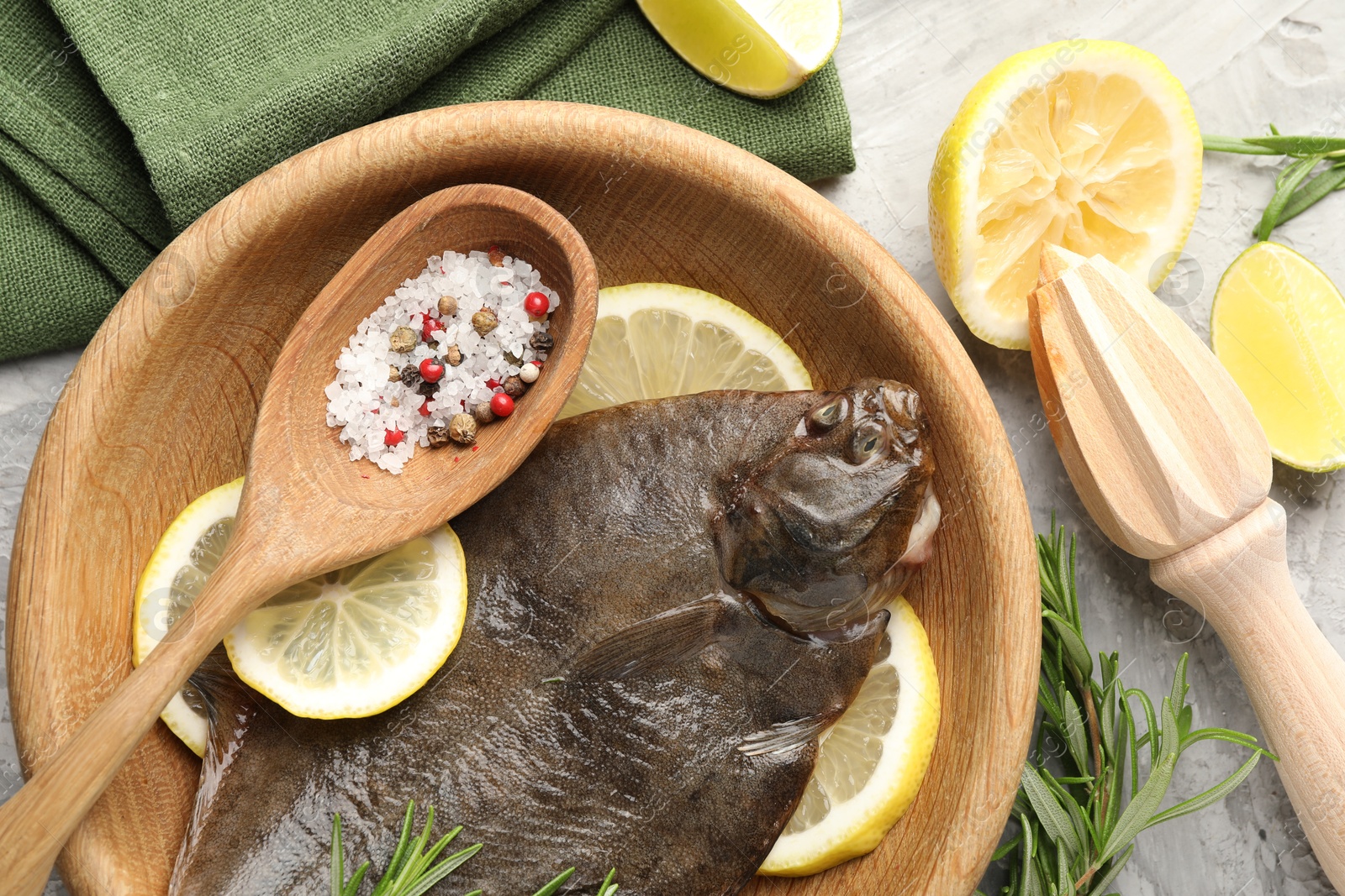Fresh raw flounder fish, spices and wooden juicer on grey table, flat lay. Seafood Photo of Fresh raw flounder fish, spices and wooden juicer on grey table, flat lay. Seafood