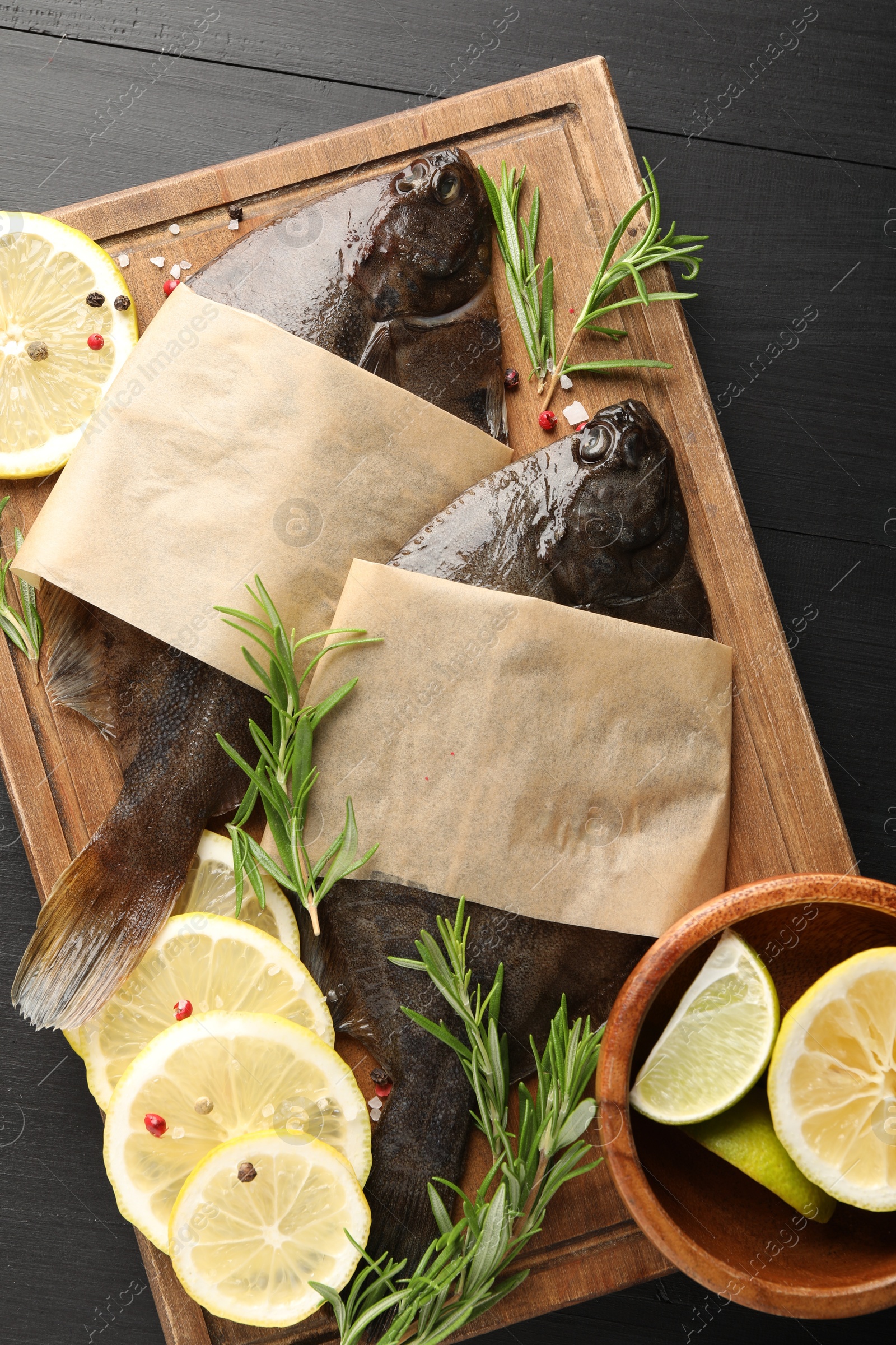 Fresh raw flounder fish and spices on black wooden table, top view. Seafood Photo of Fresh raw flounder fish and spices on black wooden table, top view. Seafood