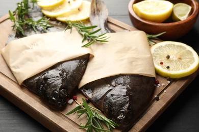 Photo of Fresh raw flounder fish and spices on black wooden table, closeup. Seafood