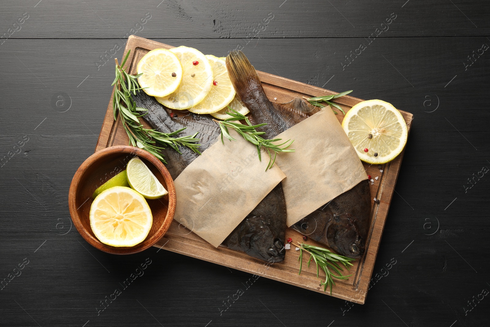 Fresh raw flounder fish and spices on black wooden table, top view. Seafood Photo of Fresh raw flounder fish and spices on black wooden table, top view. Seafood