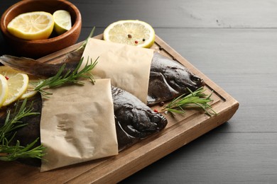 Photo of Fresh raw flounder fish and spices on black wooden table, closeup. Seafood