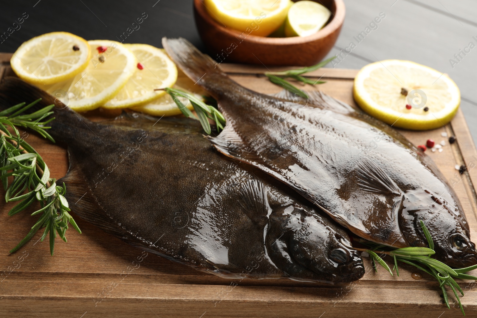Fresh raw flounder fish and spices on black wooden table, closeup. Seafood Photo of Fresh raw flounder fish and spices on black wooden table, closeup. Seafood