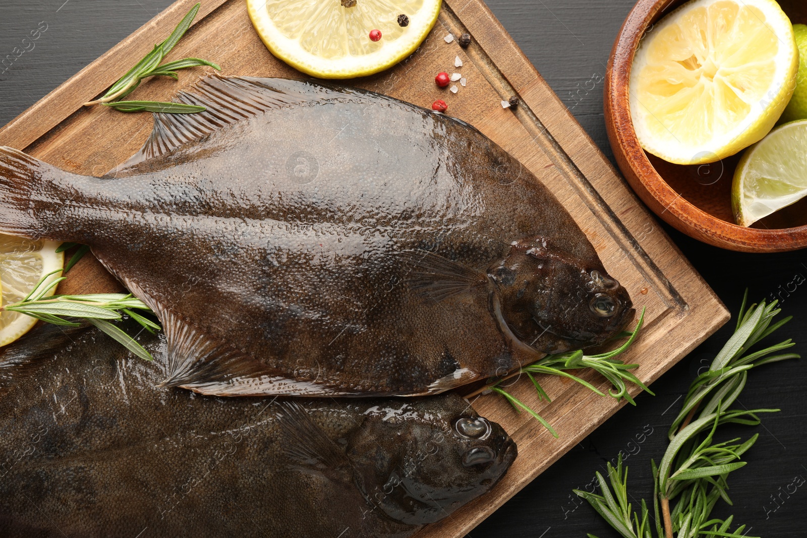 Fresh raw flounder fish and spices on black wooden table, flat lay. Seafood Photo of Fresh raw flounder fish and spices on black wooden table, flat lay. Seafood