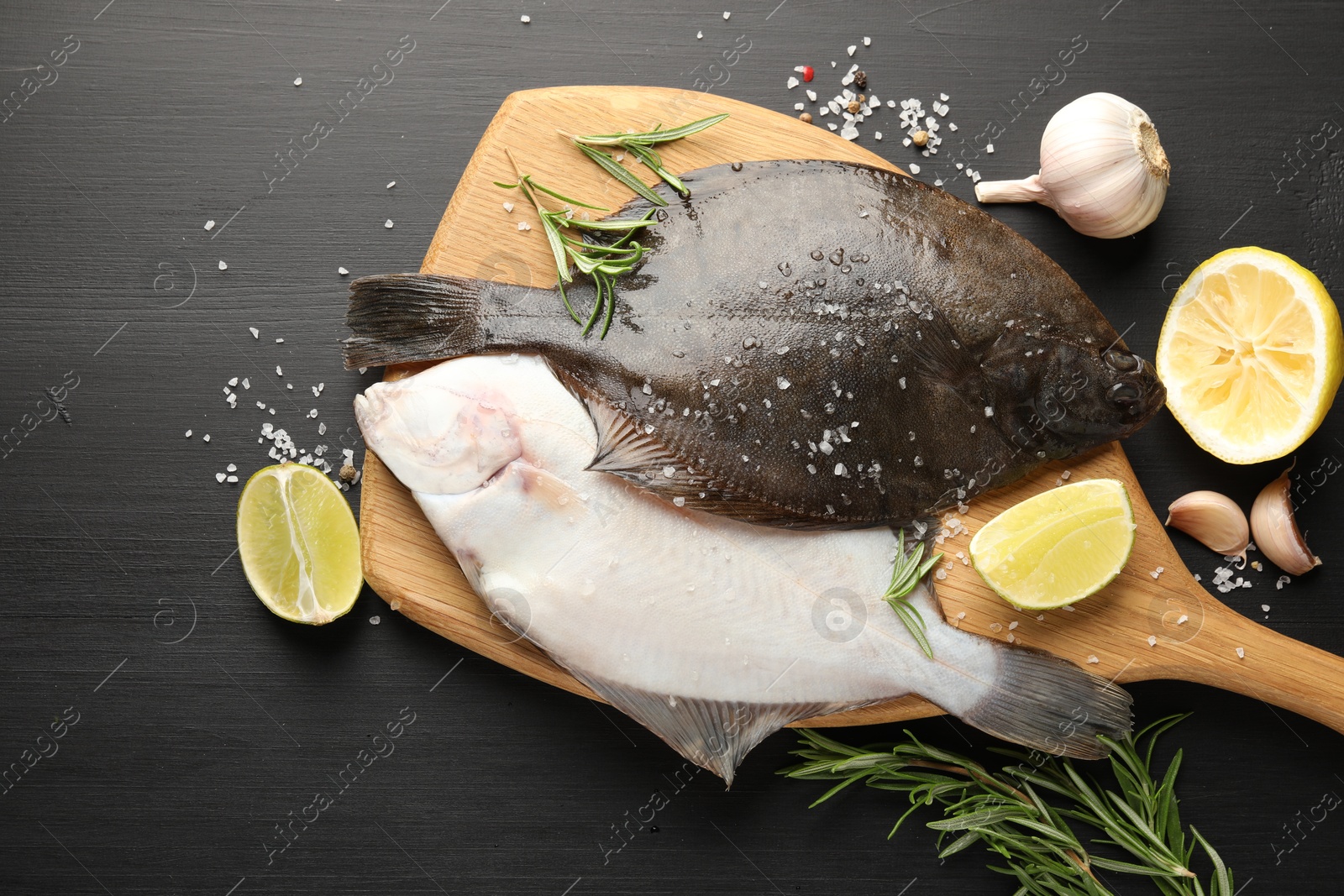Fresh raw flounder fish and spices on black wooden table, flat lay. Seafood Photo of Fresh raw flounder fish and spices on black wooden table, flat lay. Seafood