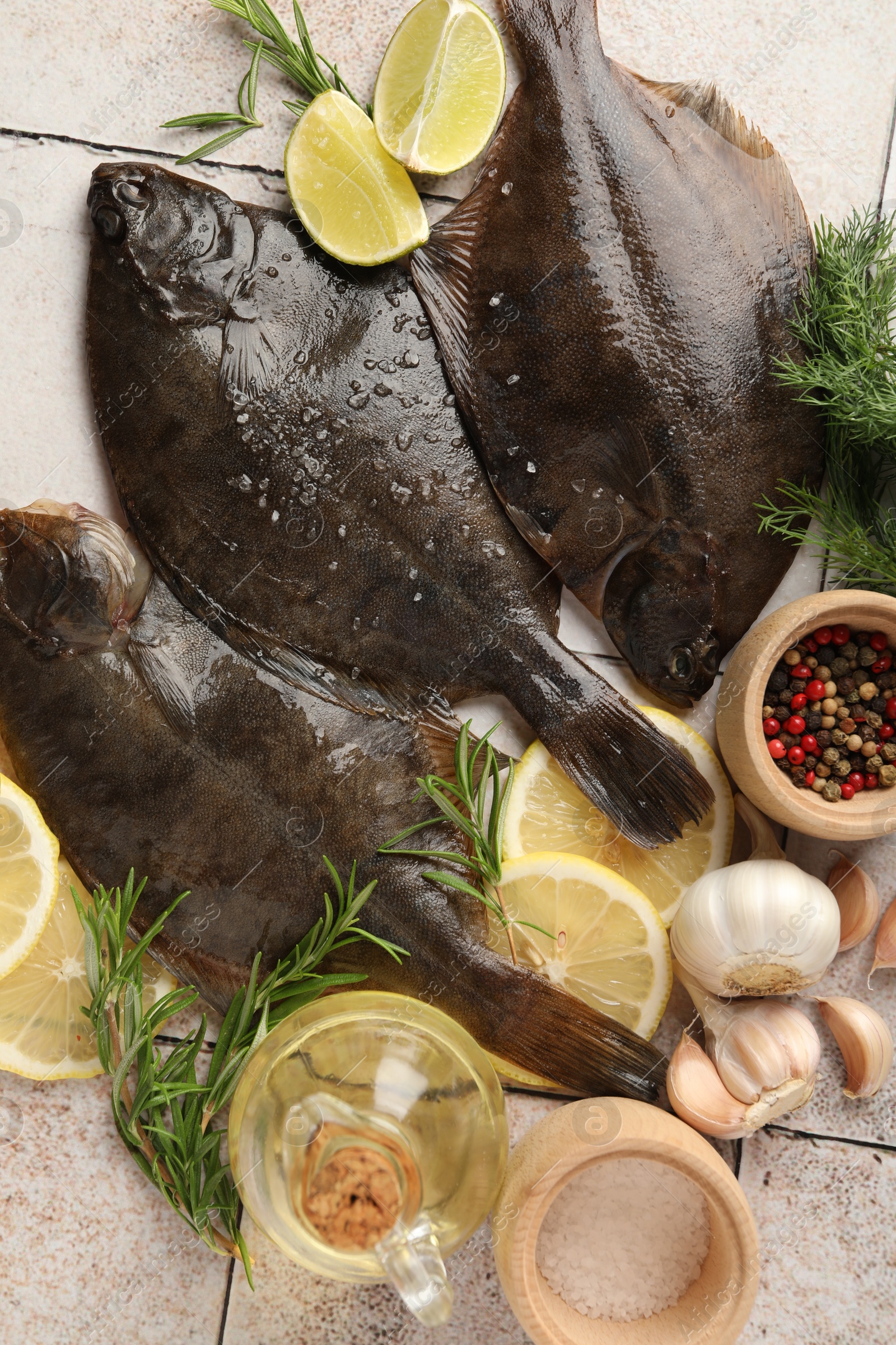 Photo of Fresh raw flounder fish and spices on light tiled table, flat lay. Seafood