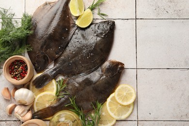 Photo of Seafood. Fresh raw flounder fish and spices on light tiled table, flat lay. Space for text