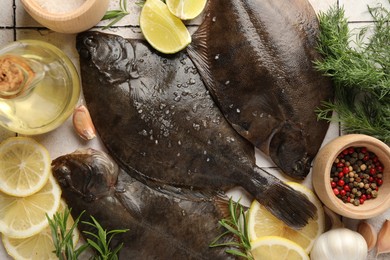 Photo of Fresh raw flounder fish and spices on light tiled table, flat lay. Seafood