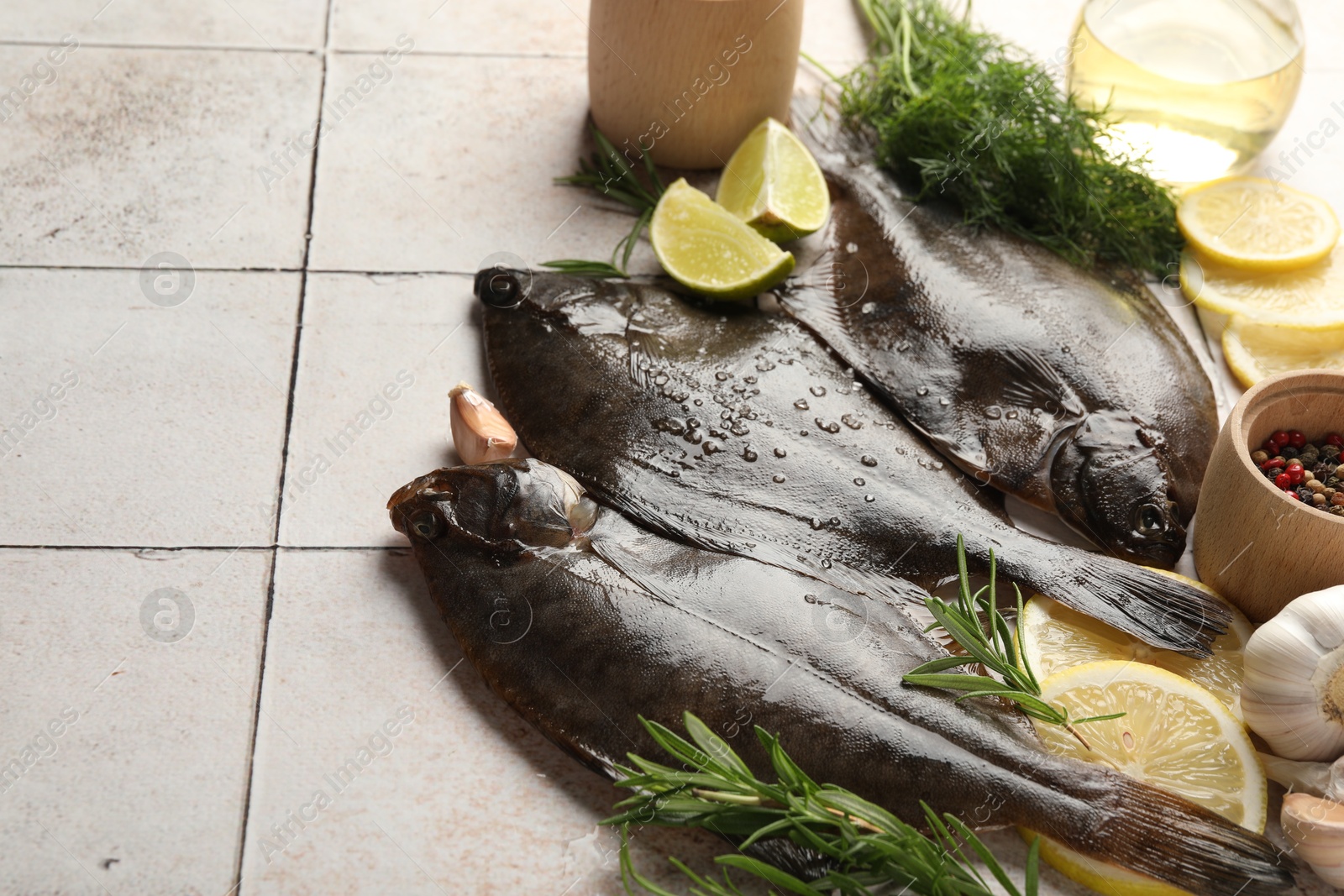Photo of Seafood. Fresh raw flounder fish and spices on light tiled table, closeup. Space for text