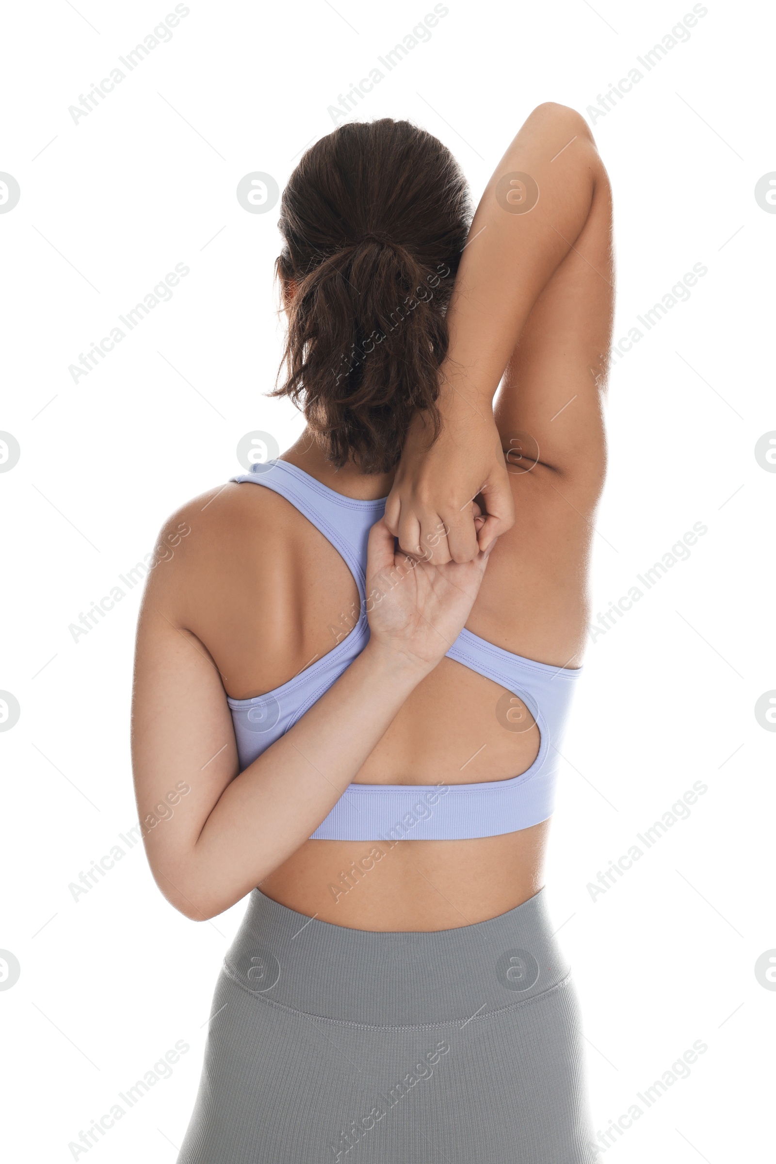 Teenage girl in sportswear stretching on white background, back view Photo of Teenage girl in sportswear stretching on white background, back view