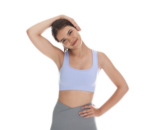 Photo of Teenage girl in sportswear stretching on white background