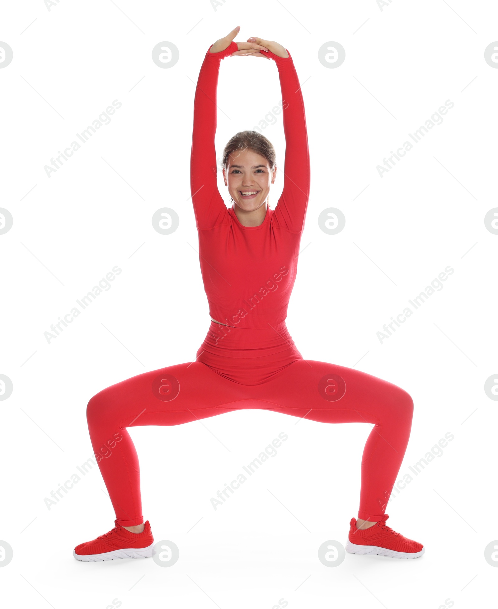 Teenage girl in sportswear stretching on white background Photo of Teenage girl in sportswear stretching on white background