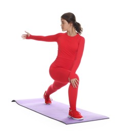 Photo of Teenage girl in sportswear stretching on mat against white background