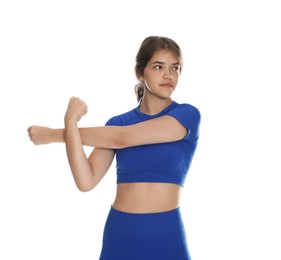 Photo of Teenage girl in sportswear stretching on white background
