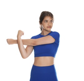 Photo of Teenage girl in sportswear stretching on white background