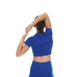 Photo of Teenage girl in sportswear stretching on white background, back view