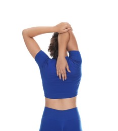 Photo of Teenage girl in sportswear stretching on white background, back view