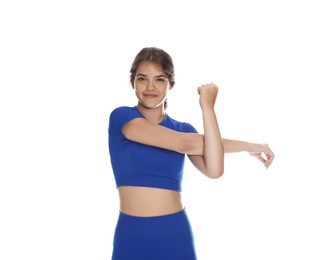 Photo of Teenage girl in sportswear stretching on white background