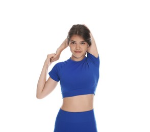Photo of Teenage girl in sportswear stretching on white background