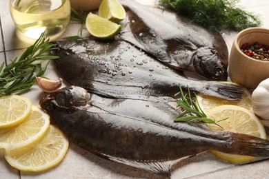 Photo of Fresh raw flounder fish and spices on light tiled table, closeup. Seafood