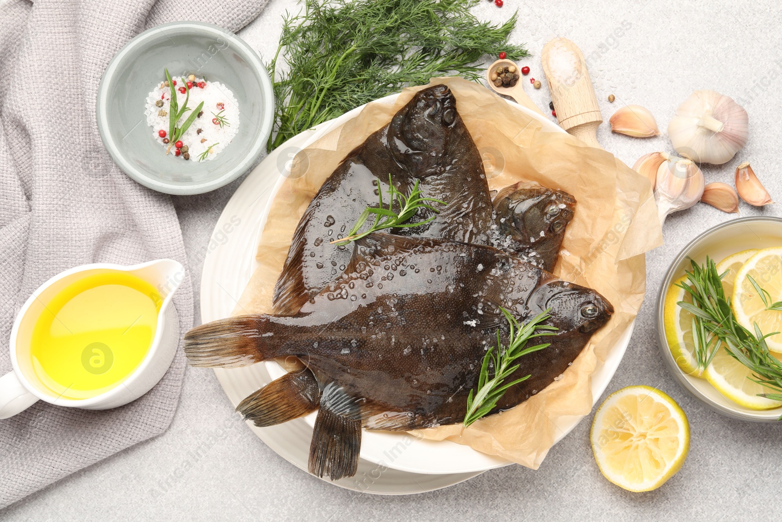 Photo of Fresh raw flounder fish and spices on light grey table, flat lay. Seafood