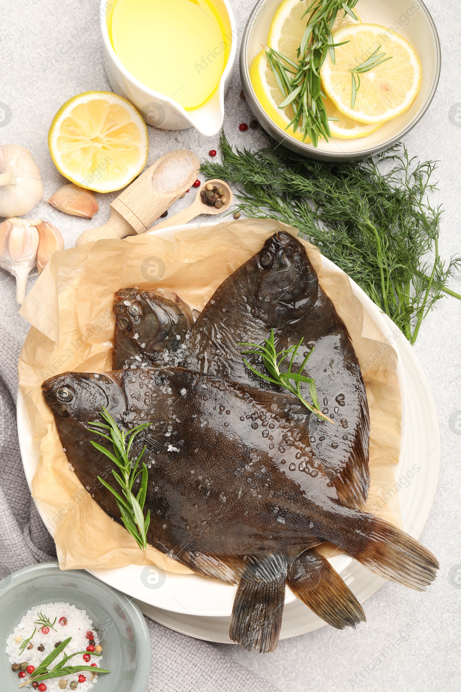Photo of Fresh raw flounder fish and spices on light grey table, flat lay. Seafood