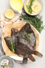 Photo of Fresh raw flounder fish and spices on light grey table, flat lay. Seafood