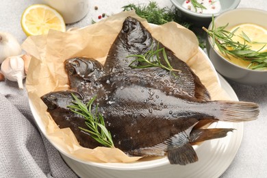 Photo of Fresh raw flounder fish and spices on light grey table, closeup. Seafood