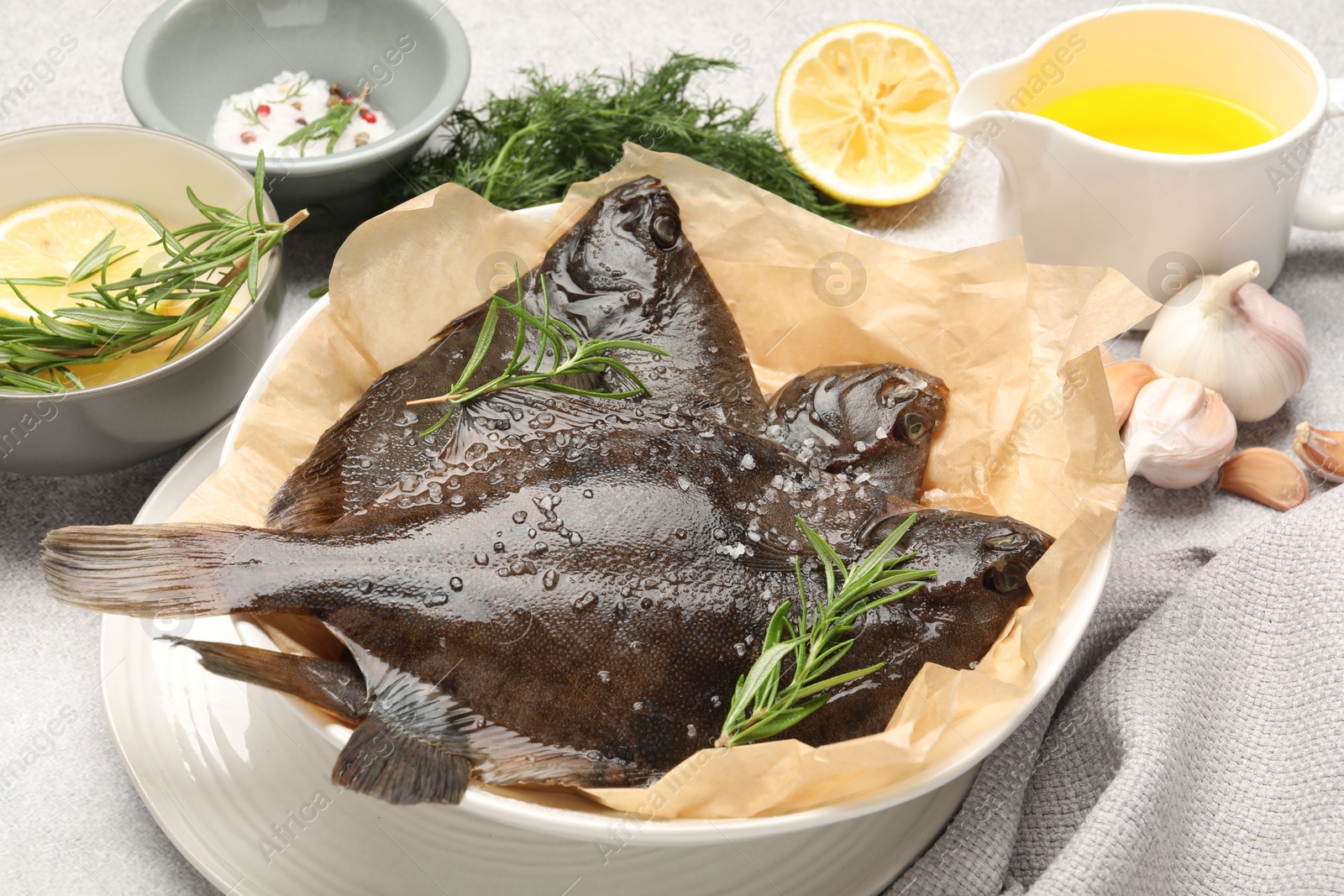 Fresh raw flounder fish and spices on light grey table, closeup. Seafood Photo of Fresh raw flounder fish and spices on light grey table, closeup. Seafood