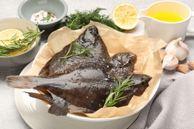Photo of Fresh raw flounder fish and spices on light grey table, closeup. Seafood