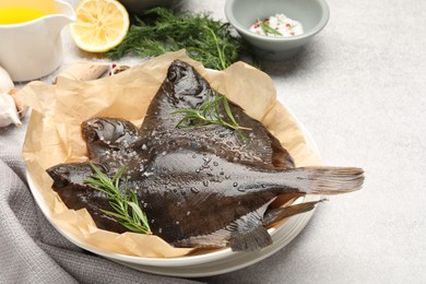 Photo of Fresh raw flounder fish and spices on light grey table, closeup. Seafood