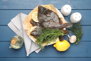 Photo of Fresh raw flounder fish and spices on blue wooden table, flat lay. Seafood