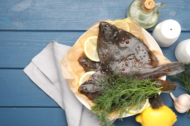 Photo of Fresh raw flounder fish and spices on blue wooden table, flat lay. Seafood