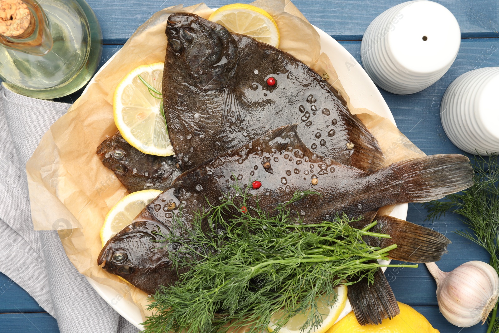 Photo of Fresh raw flounder fish and spices on blue wooden table, flat lay. Seafood
