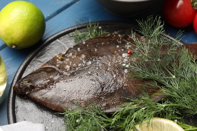 Photo of Fresh raw flounder fish and ingredients on blue wooden table, closeup. Seafood