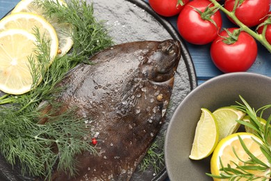 Photo of Fresh raw flounder fish and ingredients on blue wooden table, flat lay. Seafood