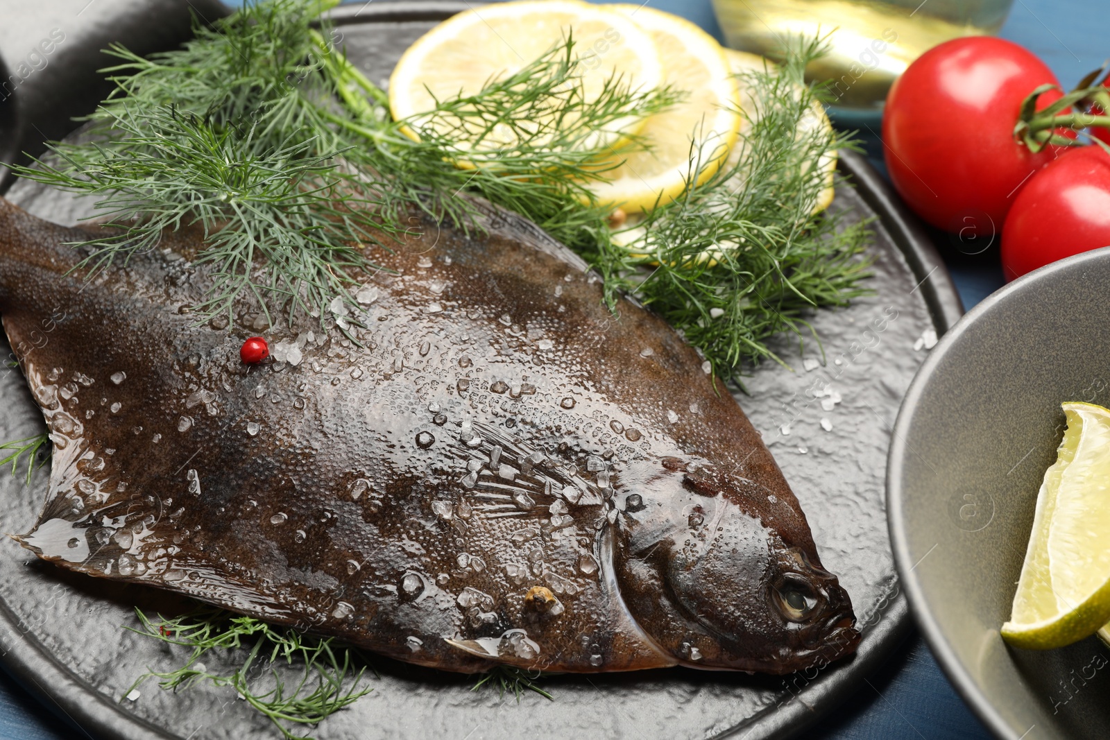 Photo of Fresh raw flounder fish and ingredients on table, closeup. Seafood
