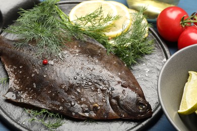 Photo of Fresh raw flounder fish and ingredients on table, closeup. Seafood