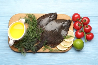 Photo of Fresh raw flounder fish and ingredients on light blue wooden table, flat lay. Seafood
