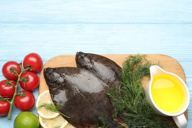 Photo of Seafood. Fresh raw flounder fish and ingredients on light blue wooden table, flat lay. Space for text
