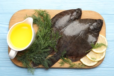 Photo of Fresh raw flounder fish and spices on light blue wooden table, flat lay. Seafood