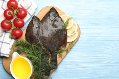 Photo of Seafood. Fresh raw flounder fish and ingredients on light blue wooden table, flat lay. Space for text