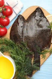 Photo of Fresh raw flounder fish and ingredients on light blue wooden table, flat lay. Seafood