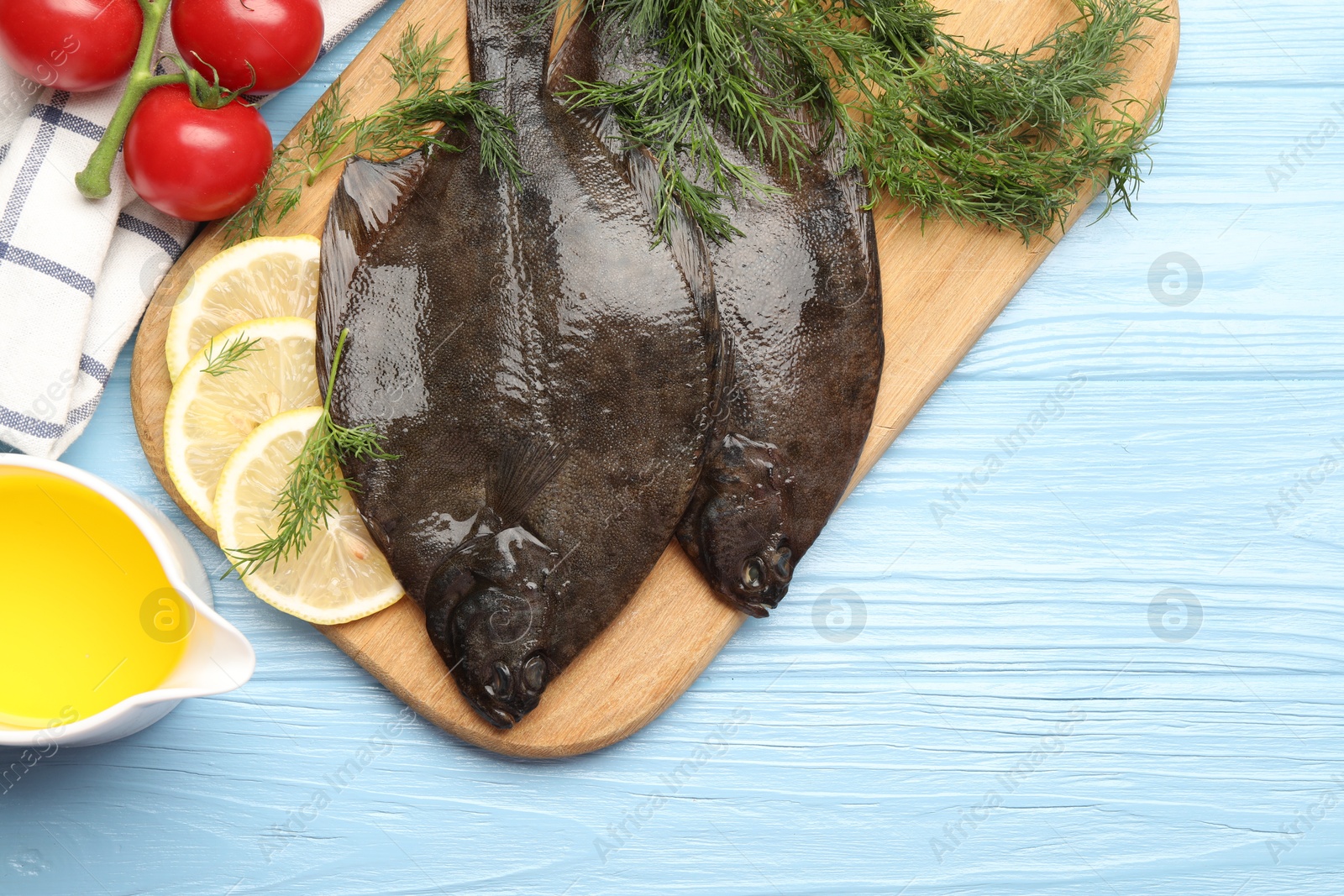 Seafood. Fresh raw flounder fish and ingredients on light blue wooden table, flat lay. Space for text Photo of Seafood. Fresh raw flounder fish and ingredients on light blue wooden table, flat lay. Space for text