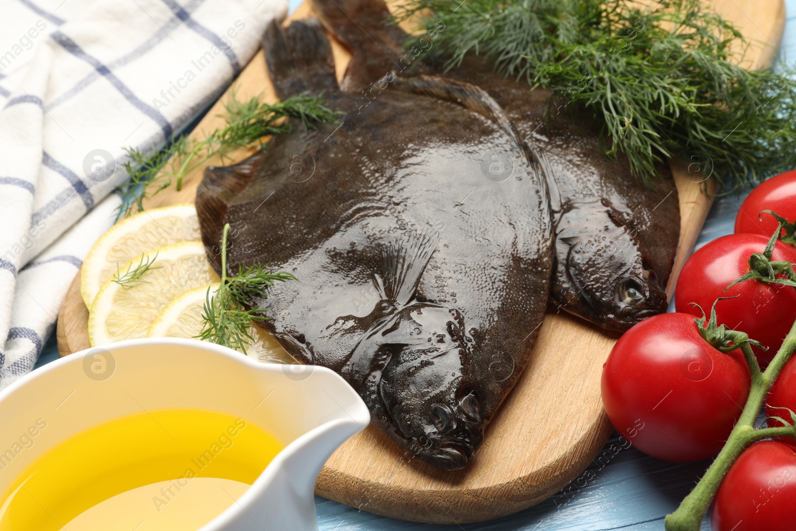 Fresh raw flounder fish and ingredients on light blue wooden table, closeup. Seafood Photo of Fresh raw flounder fish and ingredients on light blue wooden table, closeup. Seafood