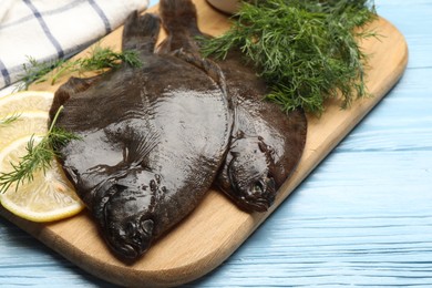 Photo of Seafood. Fresh raw flounder fish and spices on light blue wooden table, closeup. Space for text